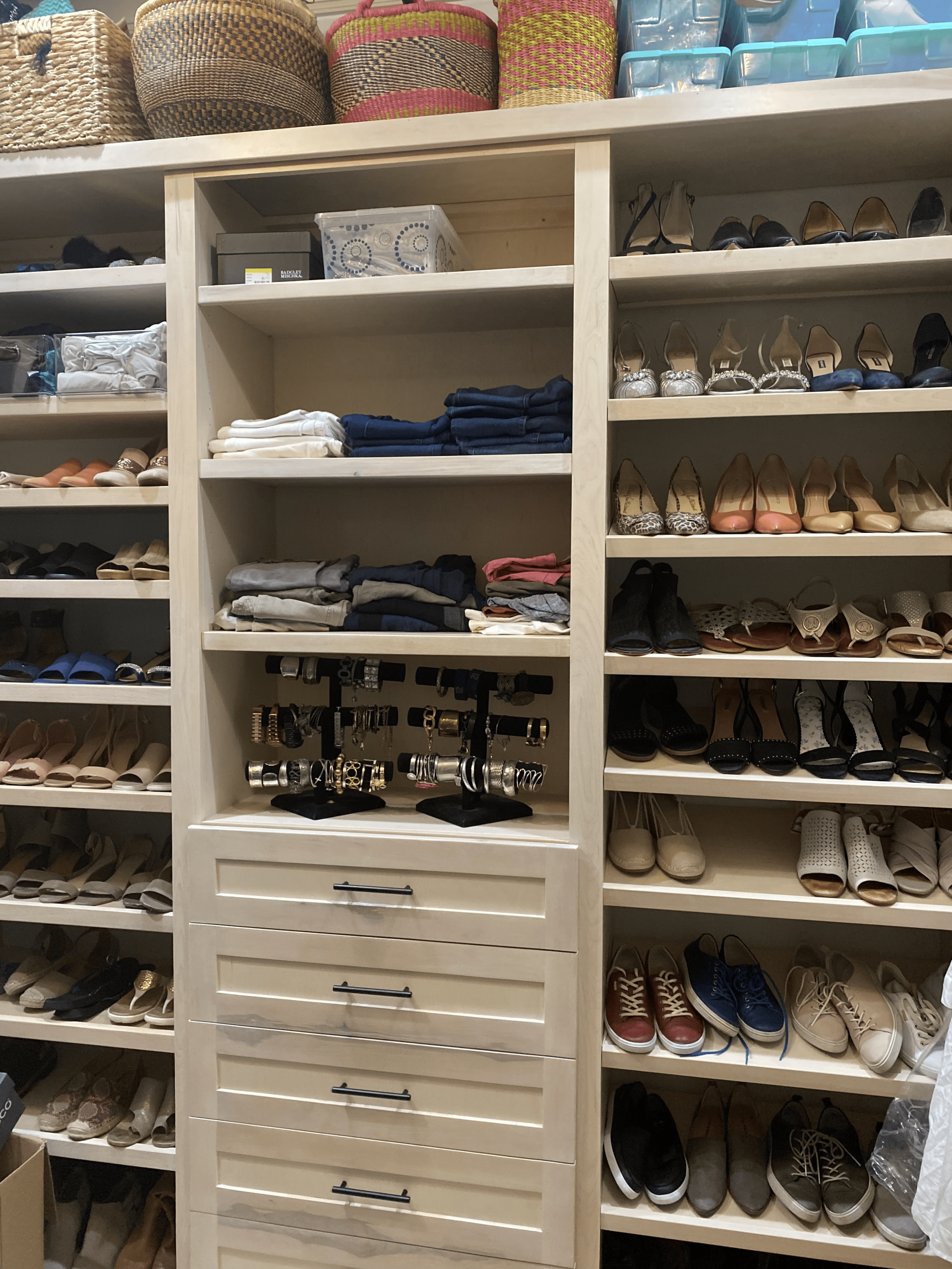 Custom walk-in closet design with built-in shelving, drawers and shoe storage